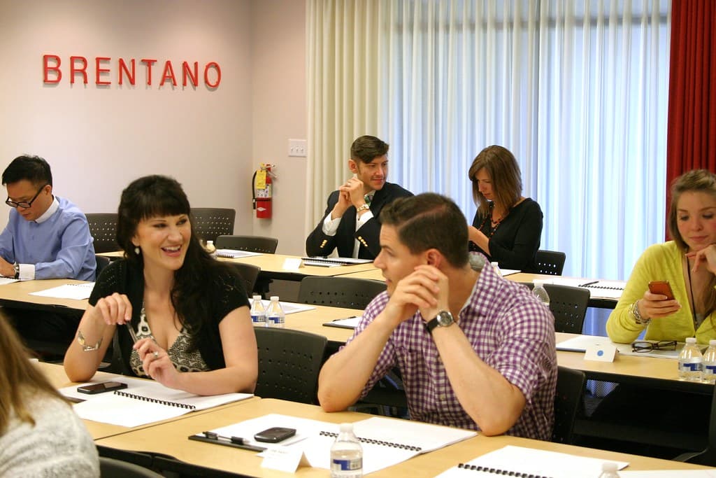 Sales team reviewing follow-up notes and phones during a meeting